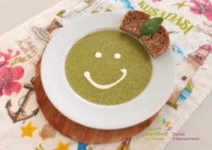 Kartoffel-Spinat-Suppe auf dem Teller serviert mit einem Smiley-Gesicht