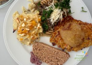 Ein üppiger Teller mit Fladenbrot, Rote Bohnen Walnussaufstrich, Steckrübenbratling mit Apfelmus, Linsensuppe mit Spirelli und Parmesan und Weißkohllasagne.