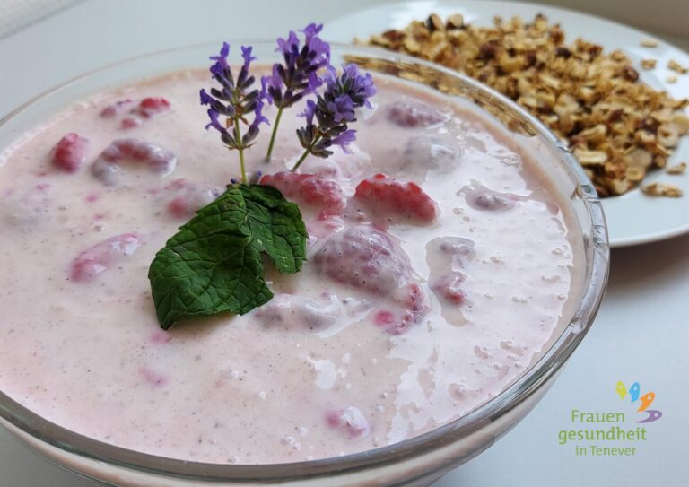 Schüssel mit Himbeer-Joghurt und Knusper-Flocken im Hintergrund als Topping