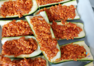 eine Auflaufform mit rohen Zucchini-Hälften gefüllt mit veganer Hackfleisch-Masse